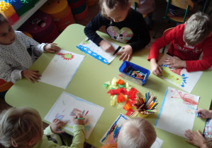 Dzieci wykonują pracę plastyczna "Jesień"